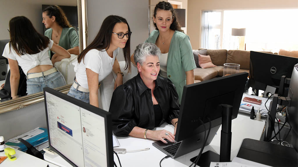 Photo of Maxine, Margot and Darcy around a screen in their home office
